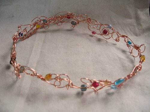 A photo of the Campbell tiara, designed by Amanda Downum. It is a circlet of copper wire and glass beads that the winner wears. It's passed on from one winner to the next.